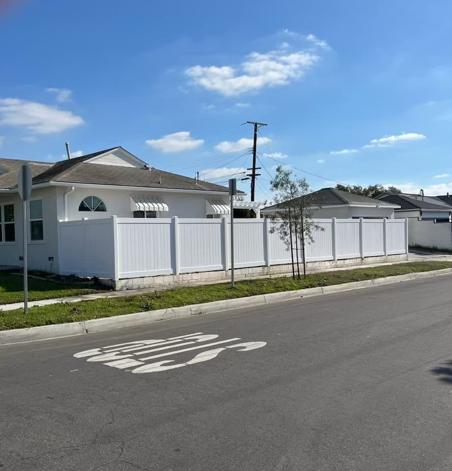 picture of white vinyl fence surrounding a suburban home