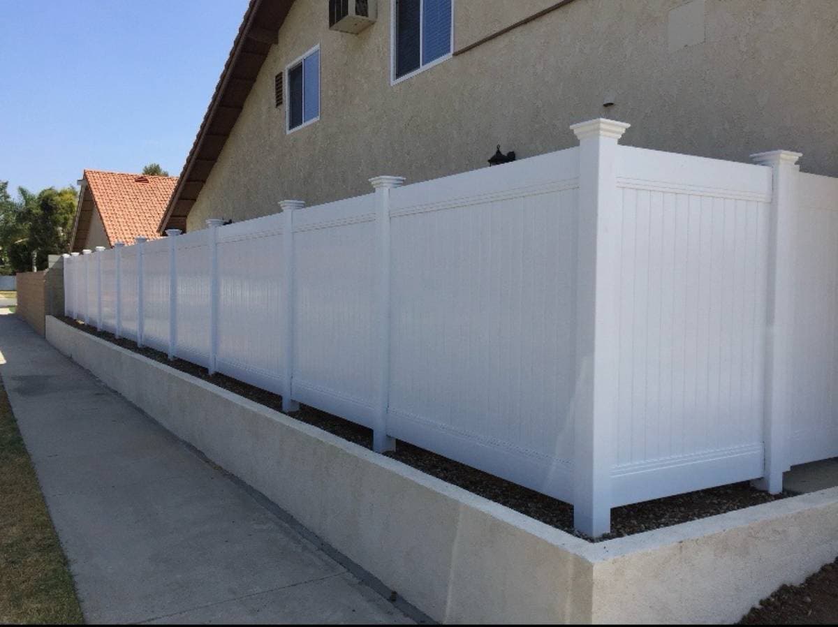 picture of white vinyl fence surrounding a side of a home 